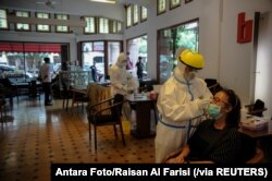 Para petugas kesehatan mengambil sampel untuk tes cepat antigen dari para pengunjung di tengah pandemi virus coronca (COVID-19) di Bandung, Jawa Barat, Rabu, 30 Desember 2020. (Foto: Antara Foto/ Raisan Al Farisi via Reuters)