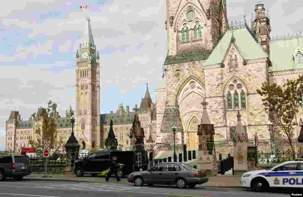 Police officers control traffic on Parliament Hill following a shooting incident in Ottawa.