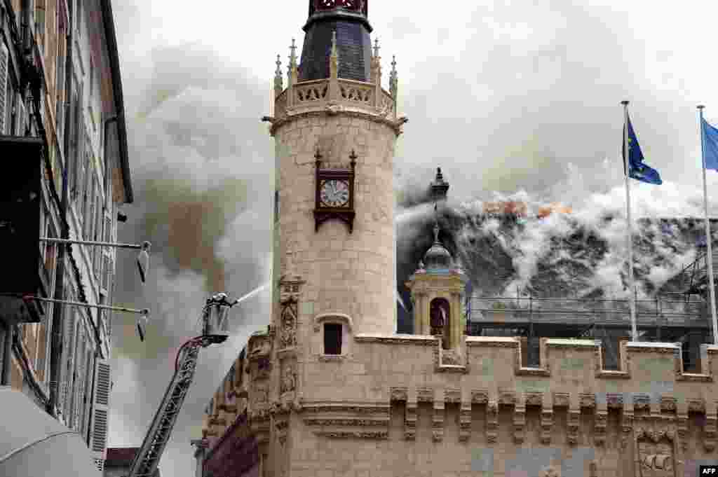 Firemen work to extinguish a fire that broke out in the city hall, in La Rochelle, western France. The fire swept through the roof destroying part of the historic 15th-century building.