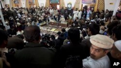 Maulana Abdul Aziz, center, in the background, the Red Mosque cleric and member of the Taliban negotiating team, addresses a news conference in Islamabad, Pakistan, Feb. 7, 2014.