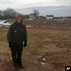 Joy Beasley, archeologist at Monocacy National Battlefield, stands next to the foundations of the slave village. The homes of the Vincendieres are in the background.