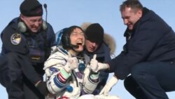 Christina Koch gives a thumbs-up signal as she leaves the Soyuz capsule in which she returned on Feb. 6, 2020.