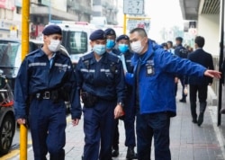 Police officers guard the building of Stand News' office in Hong Kong, Dec. 29, 2021.