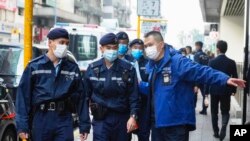 Aparat kepolisian menjaga gedung kantor Stand News di Hong Kong, Rabu, 29 Desember 2021. (Foto: AP)