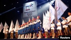 A choir sings as the emblem of the PyeongChang 2018 Olympic Winter Games is seen (top) during its Launch Ceremony in Seoul, South Korea, May 3, 2013. 