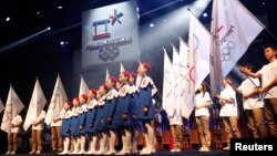 A choir sings as the emblem of the PyeongChang 2018 Olympic Winter Games is seen (top) during its Launch Ceremony in Seoul May 3, 2013. REUTERS/Kim Hong-Ji