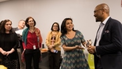 Navbahor Imamova, president of the VOA Women's Caucus, (center) speaks at a meeting of the organization.