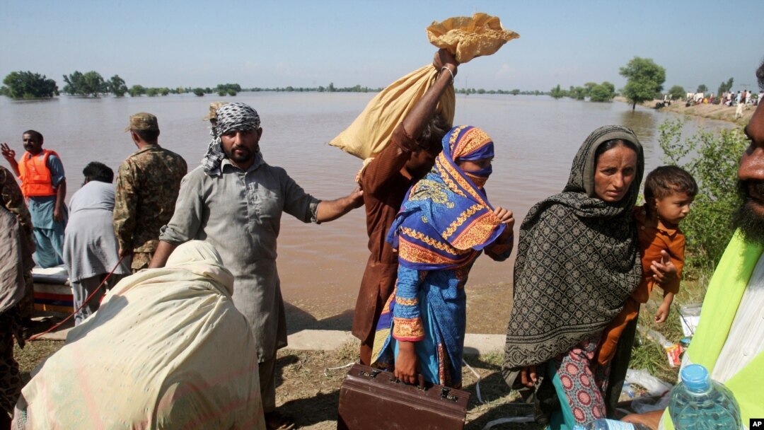 Pakistani villagers, who have been effected by the flood, arrive to find safe shelters in Pindi Bhatian, 105 kilometers (65 miles) northeast of Lahore, Pakistan, Sept. 8, 2014.
