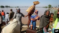 Pakistani villagers, who have been effected by the flood, arrive to find safe shelters in Pindi Bhatian, 105 kilometers (65 miles) northeast of Lahore, Pakistan, Sept. 8, 2014.