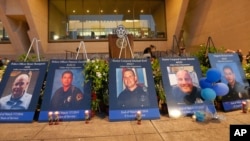 The photos of the killed police officers line the stage during a candle light vigil at City Hall on July 11, 2016, in Dallas.