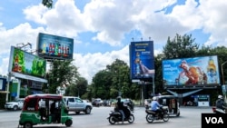 Billboards advertising alcohol seen along main roads as commuters cross the Chamkarmon intersection in Phnom Penh, on Oct. 29, 2021. (Kann Vicheika/VOA Khmer)