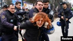 Riot police detain a demonstrator during a protest against the dismissal of academics from universities outside the Cebeci campus in Ankara, Turkey, Feb. 10, 2017. (REUTERS/Umit Bektas)