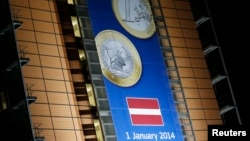 A banner showing a Latvian euro coin is seen on the facade of the European Commission headquarters in Brussels, Dec. 20, 2013.