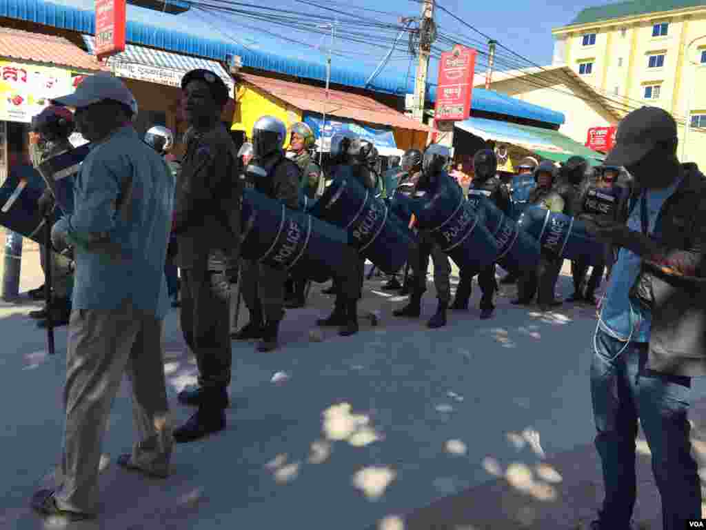 ក្រុមប៉ូលីសត្រៀមទប់ស្កាត់ជាមួយអ្នកចូលរួមធ្វើពិធីបង្សុកូលនៅព្រឹកថ្ងៃអាទិត្យទី៣ ខែមករា ឆ្នាំ២០១៦។ (ហ៊ុល រស្មី/VOA)