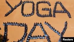 School children sit as they form the word "Yoga Day" on the International Yoga Day in Chennai, India.