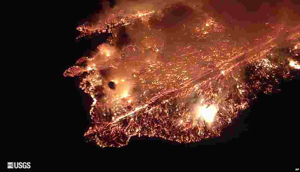 This May 27, 2018 photo provided by the U.S. Geological Survey, taken from a search aircraft, shows an outbreak of Pahoehoe lava that was very rapidly moving north down Luana Street into a portion of Leilani Estates as searchers attempted to evacuate a resident near Pahoa on the island of Hawaii.