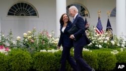 FILE - President Joe Biden walks with Vice President Kamala Harris after speaking on updated guidance on face mask mandates and COVID-19 response, in the Rose Garden of the White House, May 13, 2021, in Washington.