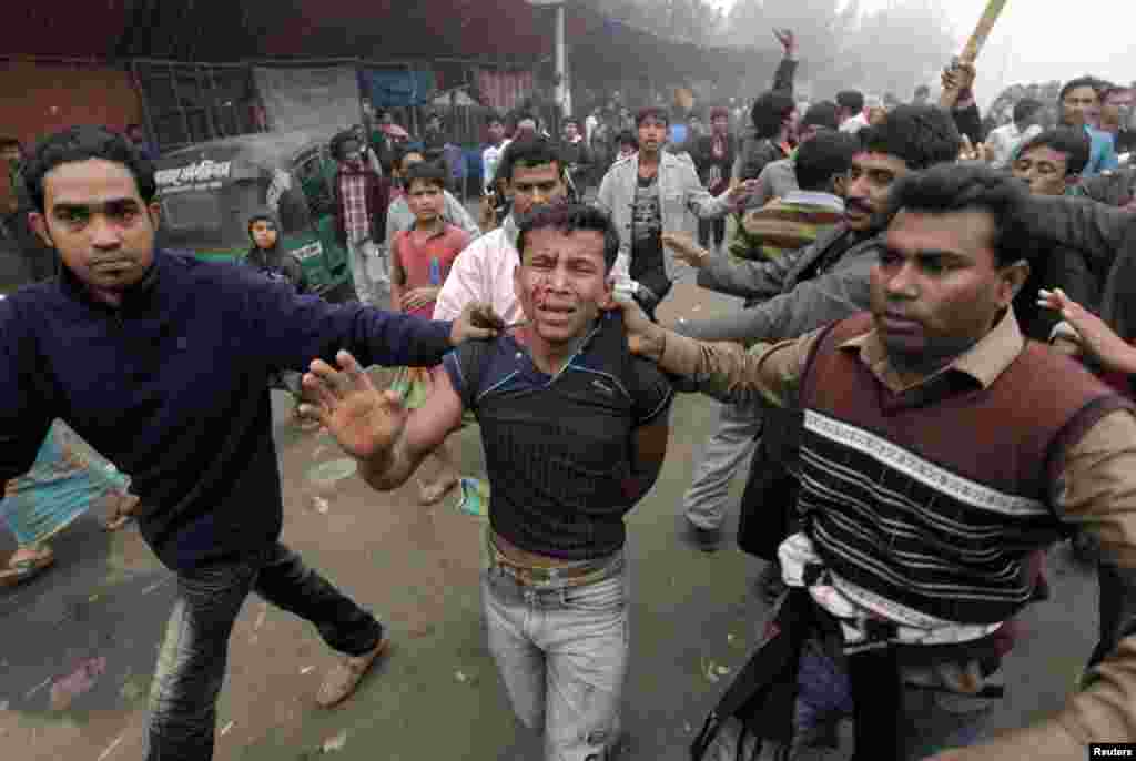 Pro-government activists attack an activist of the Bangladesh Nationalist Party (BNP), suspected of vandalising a bus, during a nationwide blockade in Dhaka December 9, 2012. Police fired rubber bullets and tear gas to disperse protesters staging blockade