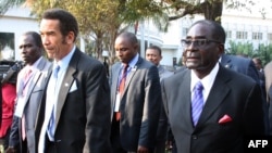 Botswana President Ian Khama (L) walks alongside Zimbabwe President Robert Mugabe (R) during a lunch break at the SADC summit in Maputo, June 15, 2013. 