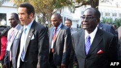 Botswana President Ian Khama (L) walks alongside Zimbabwe President Robert Mugabe (R) during a lunch break at the SADC summit in Maputo, June 15, 2013. 