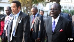 FILE: Botswana President Ian Khama (L) walks alongside Zimbabwe President Robert Mugabe (R) during a lunch break at the SADC summit in Maputo, June 15, 2013. 