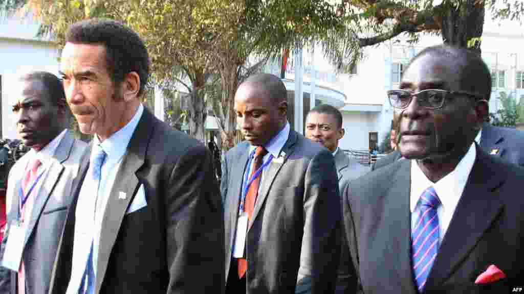 Le président du Botswana Ian Khama (G) marche aux côtés du président du Zimbabwe Robert Mugabe (G) au cours d&#39;une pause déjeuner au sommet de la SADC à Maputo. Mozambique, le 15 Juin, 2013. AFP PHOTO / FERHAT Momade 