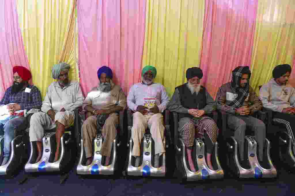 Farmers get foot massage inside a tent as they continue to demonstrate against the central government&#39;s recent agricultural reforms, blocking a highway at the Delhi-Haryana state border in Singhu, India.