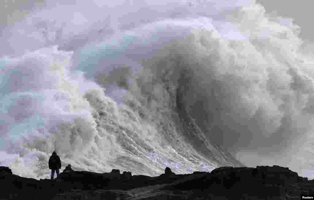 A person views large waves as Storm Eowyn arrives, in Porthcawl, Wales, Britain.