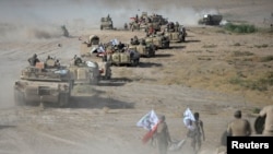 Shi'ite Popular Mobilization Forces gather with Iraqi army troops on the outskirts of Tal Afar, Iraq, Aug. 22, 2017.