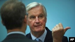 European Union chief Brexit negotiator Michel Barnier, right, speaks as he attends the weekly EU College of Commissioners meeting at EU headquarters in Brussels, Oct. 16, 2019. 