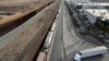 FILE - Aerial view of trucks queueing next to the border wall before crossing to the United States at Otay commercial port in Tijuana, Baja California state, Mexico, Jan. 22, 2025. 