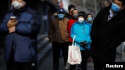 중국 베이징의 상점 밖에서 시민들이 코로나19(COVID-19)에 감염되는 것을 막기 위해 마스크를 착용하고 있다. 