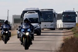French passengers leave in buses a military air base, Jan.31, 2020, in Istres, France. A planeload of French citizens from Wuhan, China, are being taken to a Mediterranean vacation resort for 14 days of quarantine.