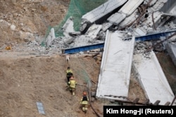 Para petugas penyelamat turut serta dalam operasi evakuasi di lokasi runtuhnya konstruksi jalan raya di Cheonan, Korea Selatan, pada 25 Februari 2025. (Foto: Kim Hong-ji/Reuters)