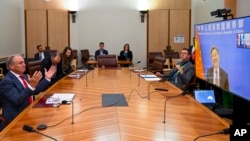 Australian Trade Minister Don Farrell, left, gestures as he speaks to China's Minister of Commerce, Wang Wentao during a meeting via teleconference at Parliament House in Canberra, Australia, Feb. 6, 2023. 