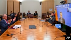 Australian Trade Minister Don Farrell, left, gestures as he speaks to China's Minister of Commerce, Wang Wentao during a meeting via teleconference at Parliament House in Canberra, Australia, Feb. 6, 2023.