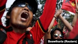 Para pekerja meneriakkan slogan-slogan dalam protes terhadap keputusan pemerintah untuk merevisi upah minimum di depan Istana Kepresidenan di Jakarta, 15 Oktober 2015. (Foto: Reuters/Beawiharta)