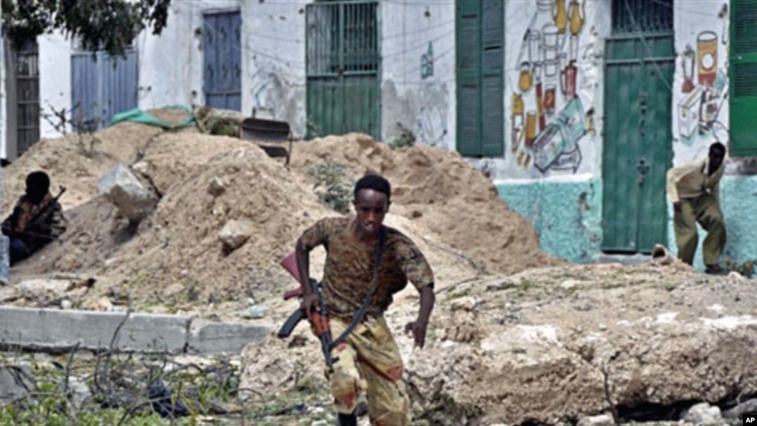 A government soldier runs for cover during heavy clashes in northern Mogadishu, 11 Mar 2010, in a second day of intense fighting between Somali government troops and insurgent forces
