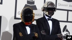 法國電音二人組合“蠢朋克”戴著機器人頭盔面具抵達洛杉磯第56屆格萊美獎頒獎典禮會場。（2014年2月26日）