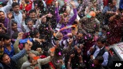 India’s main opposition Bharatiya Janata Party, (BJP) supporters celebrate the party’s victory in the Delhi state Assembly elections in New Delhi, Dec. 8, 2013.