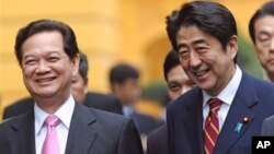 日本首相安倍晉三(右)1月16 日抵達越南﹐在河內和越南總理阮晉勇(左)談笑。