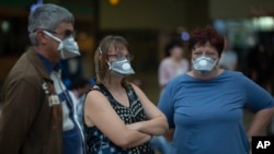 People wearing masks wait for passengers at Johannesburg's O.R. Tambo International Airport, South Africa, March 16, 2020, a day after President Cyril Ramaphosa declared a national state of disaster.