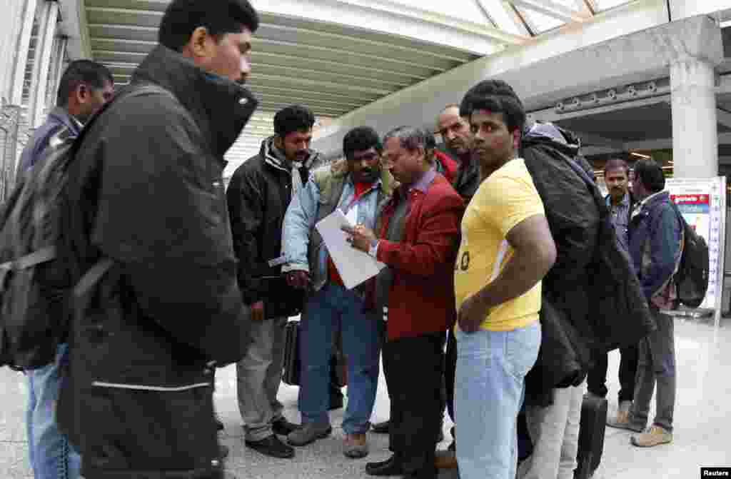 Oil workers from India and Pakistan check them in a list before boarding their flight after arriving to Palma de Mallorca airport at Spanish Balearic island of Mallorca, January 18, 2013. Oil workers evacuated from Algeria following an Al Qaeda linked att