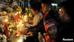 Keluarga korban ledakan bom Bali tahun 2002 menyalakan lilin untuk memperingati 13 tahun peristiwa bom Bali, di Tugu Peringatan Bom Bali di Kuta. (Foto: Antara via Reuters)