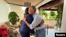 Presidential candidate Xiomara Castro of the Liberty and Refoundation Party is embraced by Nasry Asfura, presidential candidate of the ruling National Party, after Asfura conceded, in Tegucigalpa, Honduras Nov. 30, 2021.