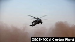 미군 조종사들이 중동에서 AH-64 아파치 공격 헬리콥터로 비행 준비를 하고 있다.