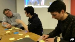 James Tabor (R) and other Tech For U.K. volunteers discuss ideas for anti-Brexit digital products in London, March 14, 2019.