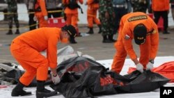 Spasioci nose vreću u kojoj su posmrtni ostaci ljudi izvučeni iz voda u koje je pao avion Srividžaja era, u Tanjung Prioku in Jakarta, Indonezija, 10. januara 2021.