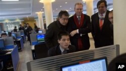 Pemimpin Google, Eric Schmidt (tiga dari kiri) dan mantan Gubernur Mexico Bill Richardson (dua dari kanan) mengawasi seorang mahasiswa menjelajahi internet di laboratorium komputer Universitas Kim Il Sung University di Pyongyang, Korea Utara, 8 Januari 2013. (AP Photo/David Guttenfelder)