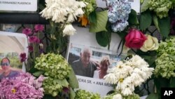 This June 29, 2021, photo shows a memorial wall for the victims of the Champlain Towers South building collapse in Surfside, Fla., with a photo of Juan Mora Sr. and his wife, Ana Mora.